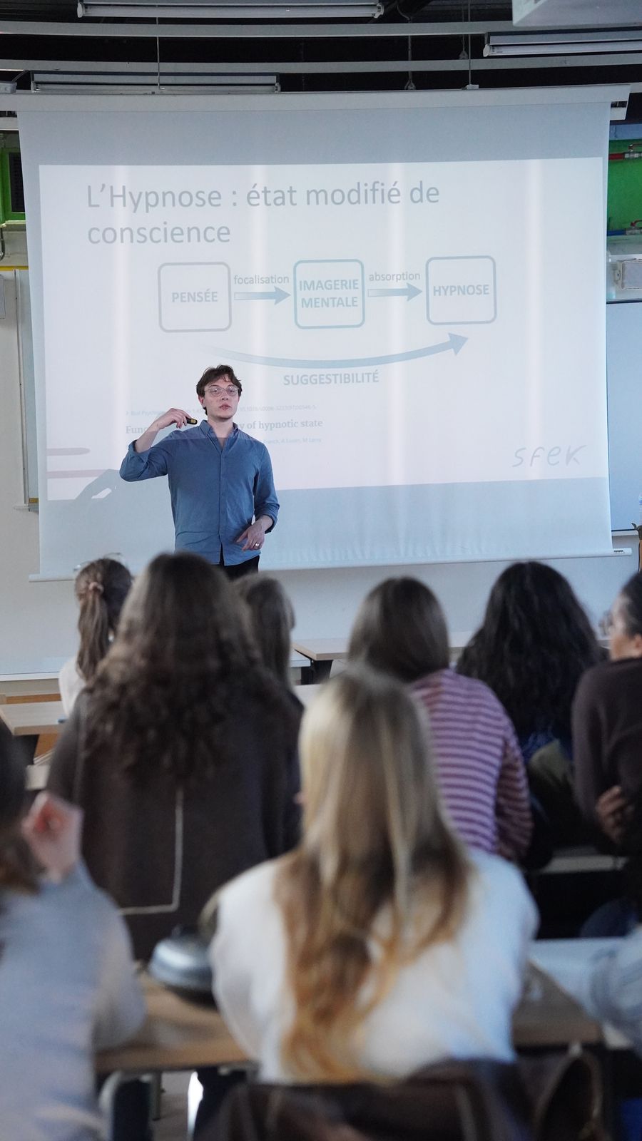 Stéphane Carapelle présentant l'hypnose comme état modifié de conscience devant une salle d'étudiants