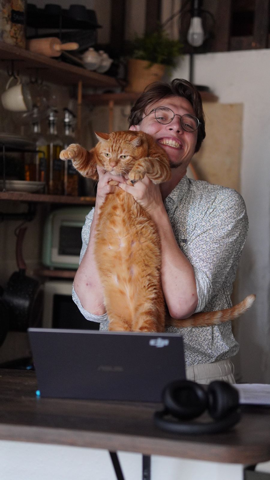 Stéphane Carapelle, souriant, tenant son chat roux dans les bras